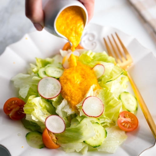 Carrot ginger dressing drizzled on the refreshing iceberg lettuce and cucumber slices.
