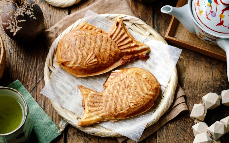 Taiyaki, Japanese fish-shaped cakes, placed on a woven basket lined with a parchment paper.